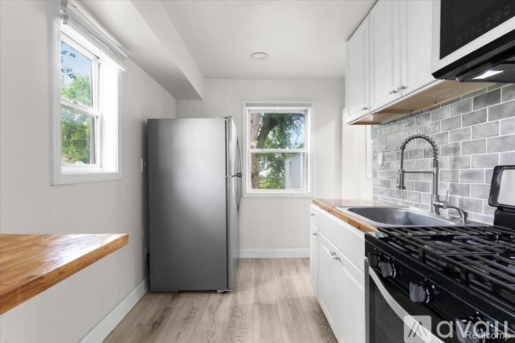 A kitchen with a stainless steel refrigerator and a black stove top.