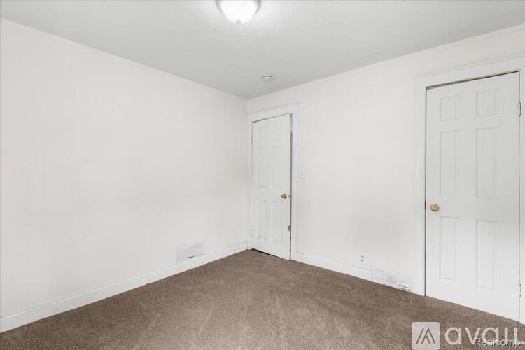 A room with two doors and a carpeted floor.