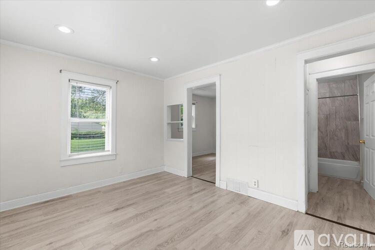 A room with a window and a door is available for rent.