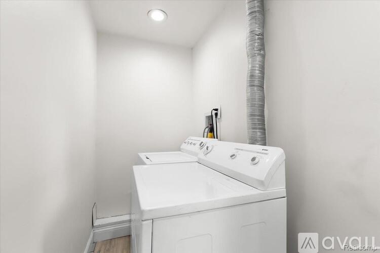 A white washing machine in a small laundry room.