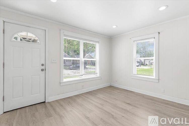 A room with a white door and two windows with white frames.