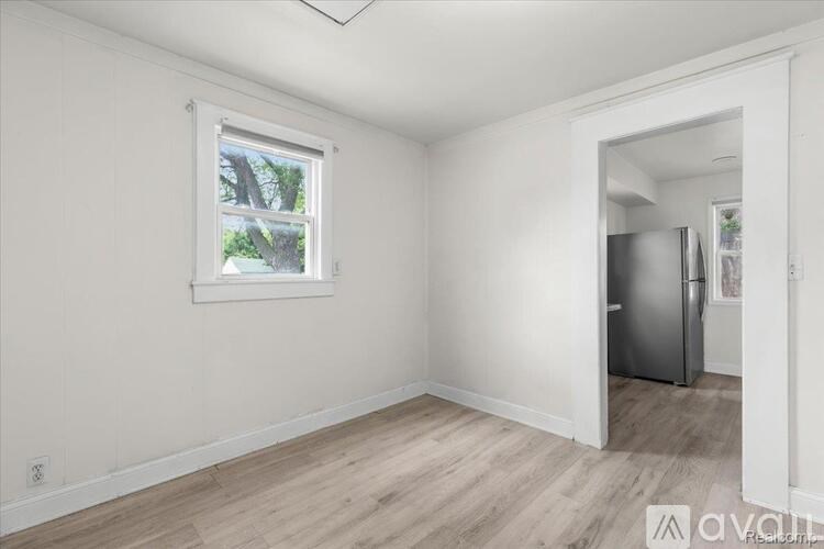 A room with a window and a door leading to another room.