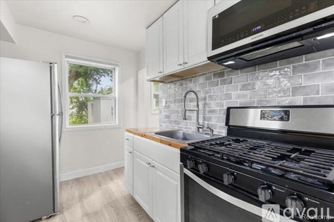 A kitchen with a stove top oven and a refrigerator.