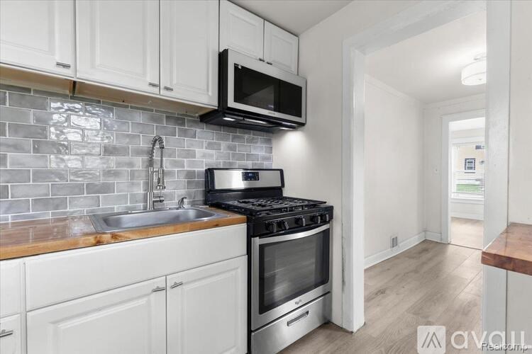A kitchen with a black microwave above the stove.