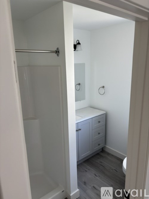 A bathroom with a toilet, sink, and shower.