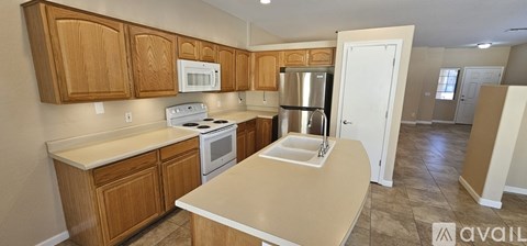 A kitchen with wooden cabinets and a white stove top oven.
