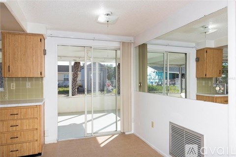 A kitchen with wooden cabinets and a white wall.