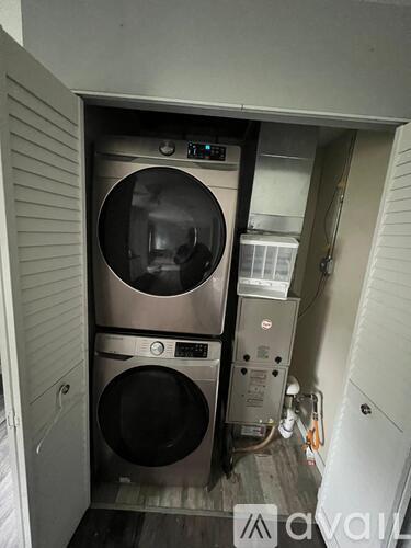 A washer and dryer stacked on top of each other in a small room.