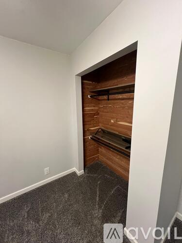 A room with a white wall and a wooden staircase.