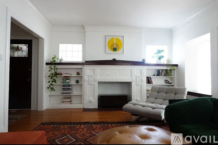 A living room with a fireplace and a green couch.