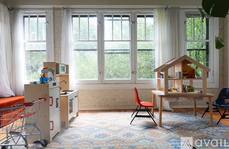 A room with a table, chairs, and a dollhouse.
