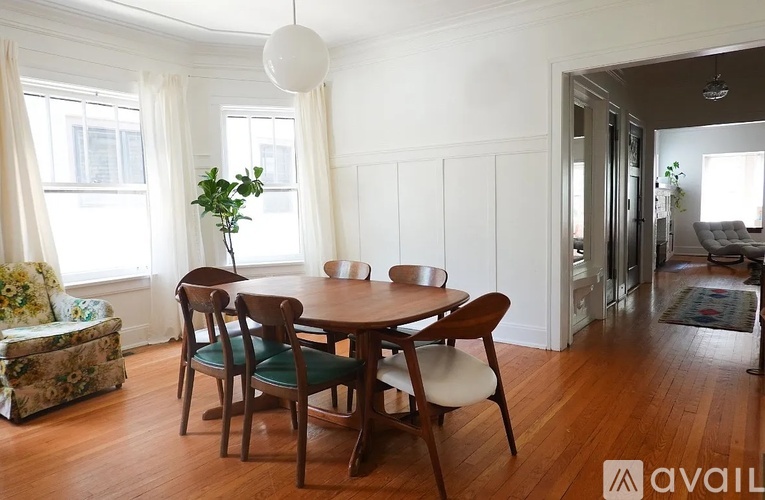 A dining room with a wooden table and chairs.