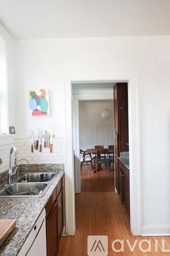 A kitchen with a sink and a painting on the wall.