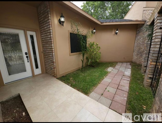A patio area with a brick walkway and a flat screen TV mounted on the wall.