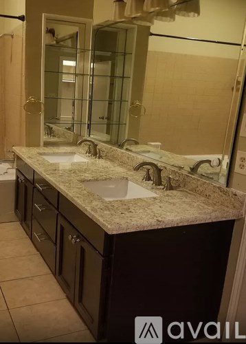 A bathroom with a granite countertop and a large mirror.