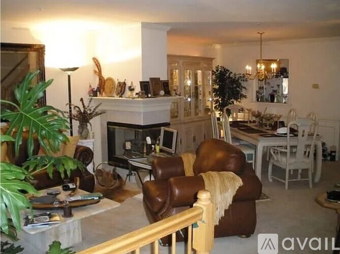 A living room with a brown leather chair and a white couch.