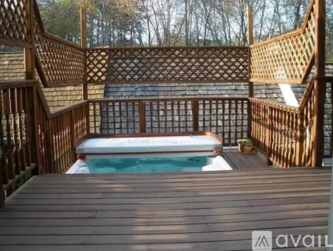 A wooden deck with a hot tub in the middle.