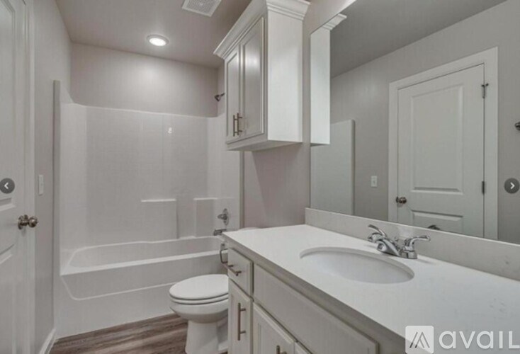 A white bathroom with a toilet, sink, and bathtub.