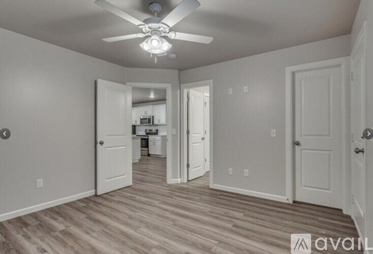 A room with a ceiling fan and wooden flooring.