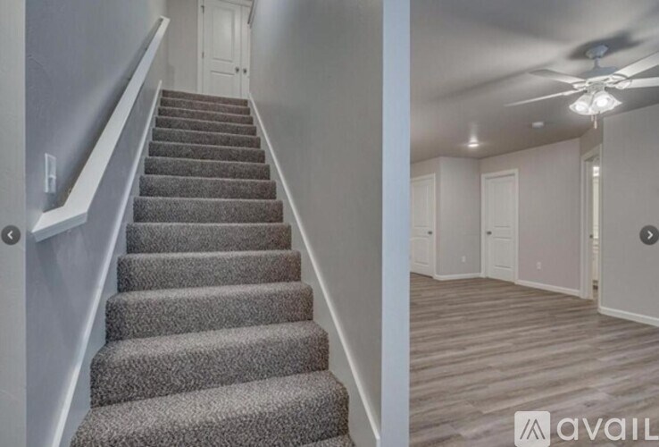 A staircase with a carpeted runner and a white railing leads to a room with a ceiling fan.