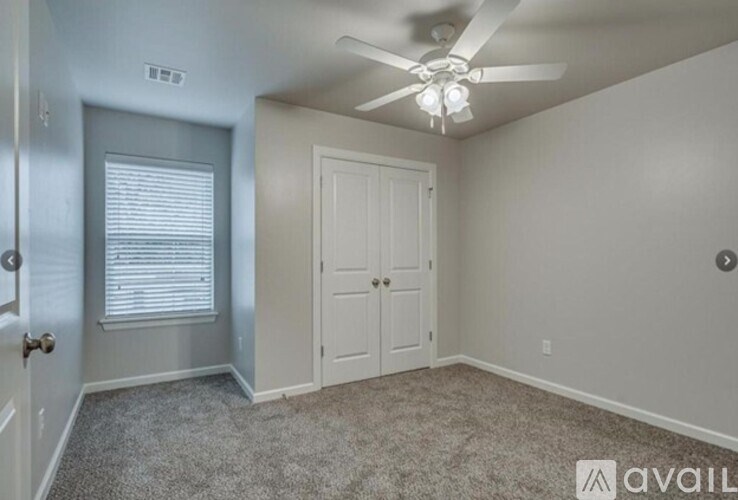 A room with a ceiling fan and a door.