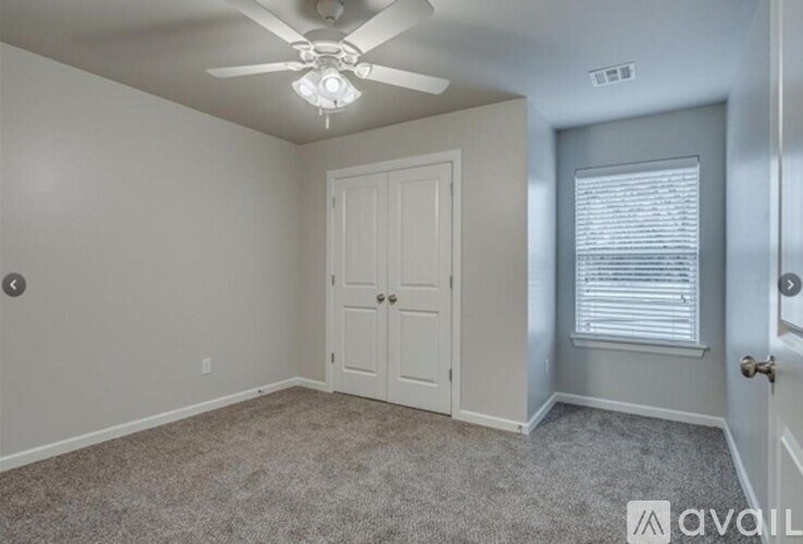 A room with a ceiling fan and a door.