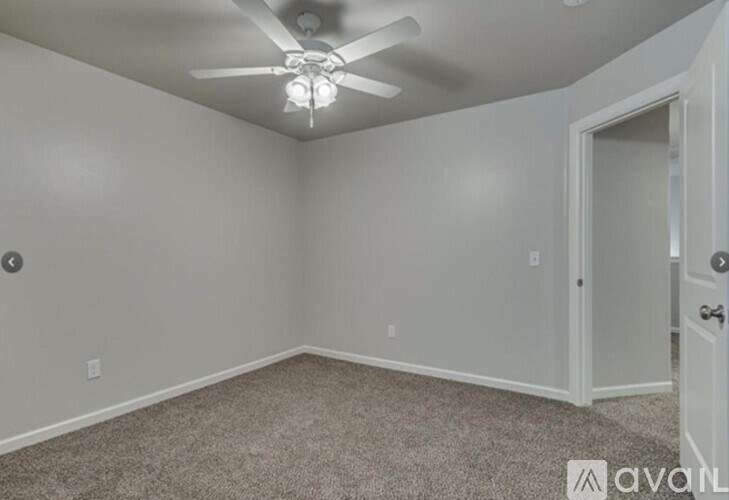 A room with a ceiling fan and carpeted floor.