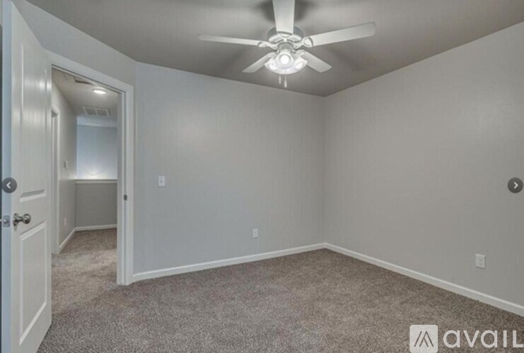 A room with a ceiling fan and carpeted floor.