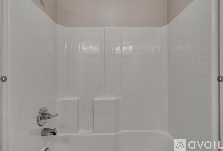 A white bathroom with a shower and a door.