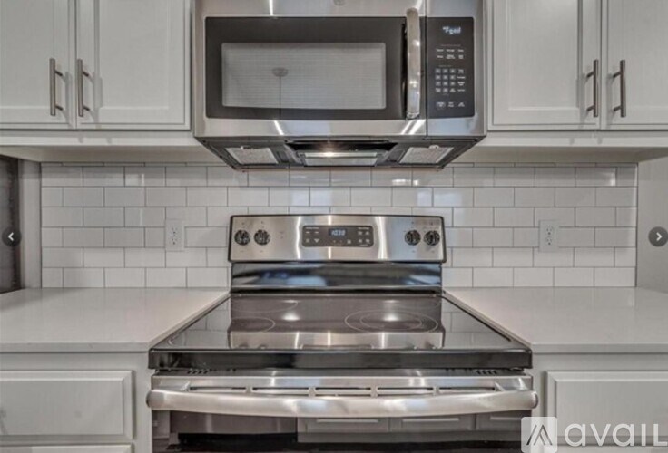 A modern kitchen with a stainless steel oven and microwave above it.