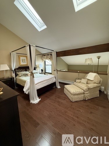 A bedroom with a canopy bed and a chair.