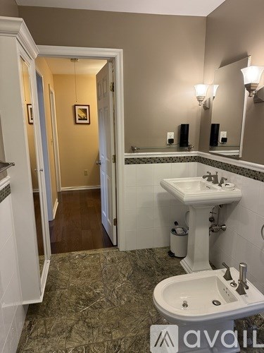 A bathroom with a sink, toilet and mirror.