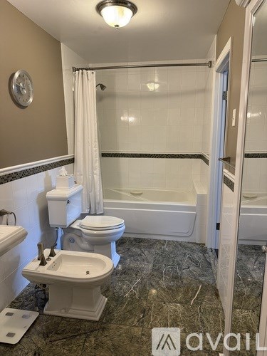 A bathroom with a toilet, sink, and bathtub.