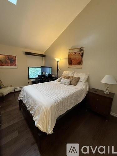 A bedroom with a bed, nightstand, and lamp.