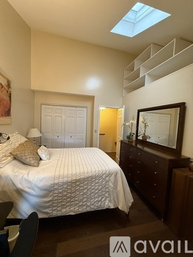 A bedroom with a bed, dresser, and mirror.
