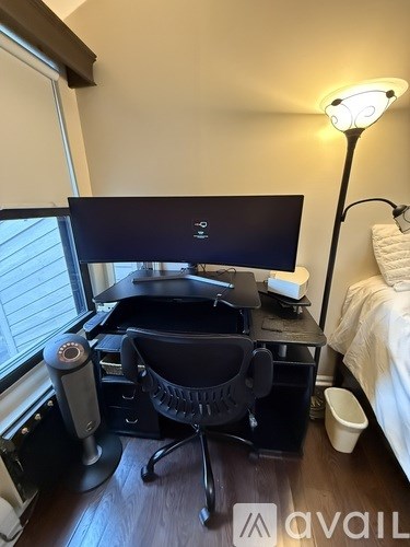 A black computer desk with a monitor, keyboard, and mouse.