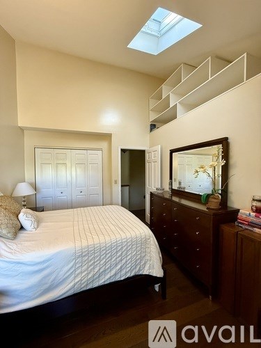 A bedroom with a bed, dresser, and mirror.