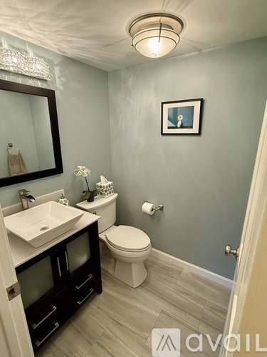 A bathroom with a toilet, sink, and mirror.