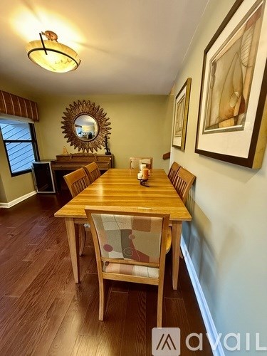 A bedroom with a bed, a dresser, and a window with curtains.