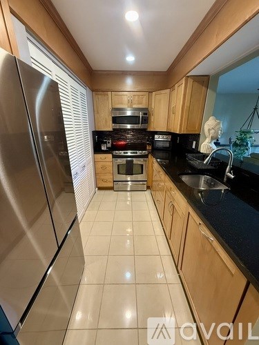 A kitchen with a refrigerator on the left and a sink on the right.