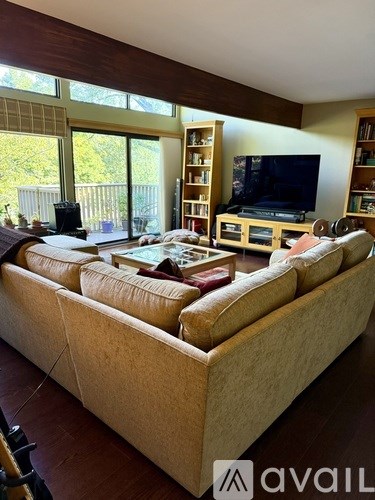 A living room with a large couch and a television.