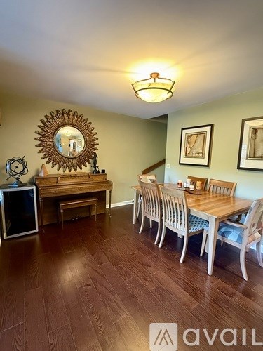 A dining room with a wooden table and chairs.