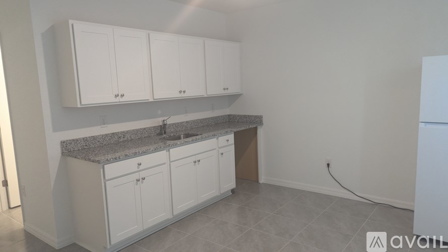 A kitchen with white cabinets and a granite countertop.