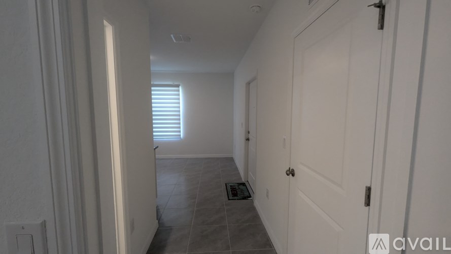 A white door is on the right side of a hallway.