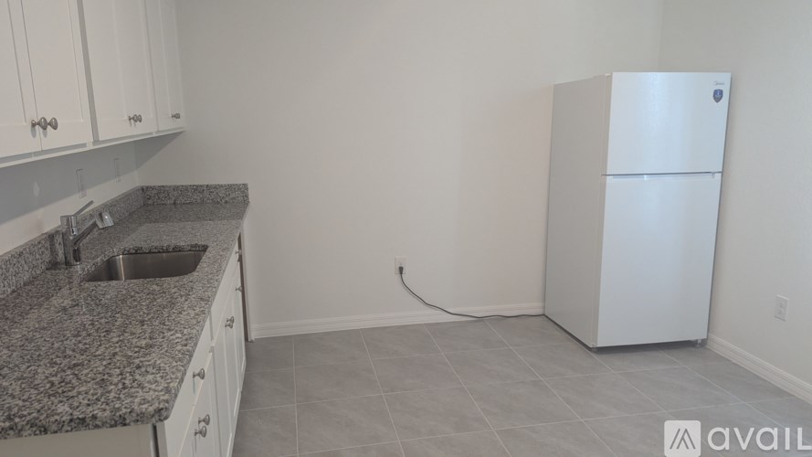 A kitchen with granite countertops and white cabinets.