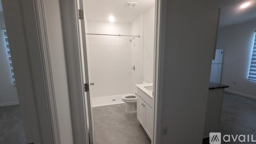 A bathroom with a toilet, sink, and shower.
