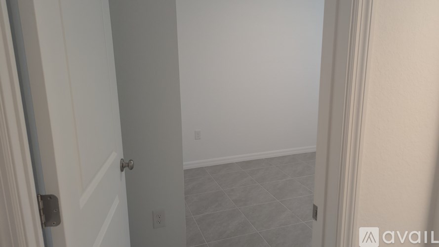A hallway with a tiled floor and white walls.