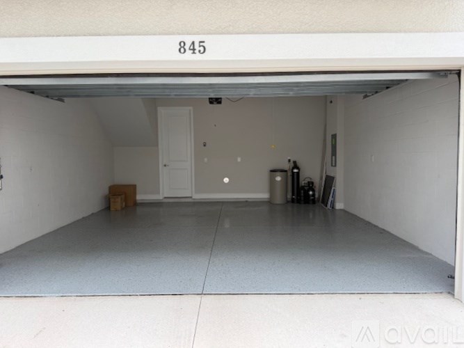 A black and beige trash can with a white label on it.