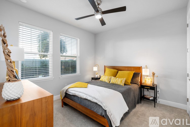 A bedroom with a bed, nightstand, and a ceiling fan.