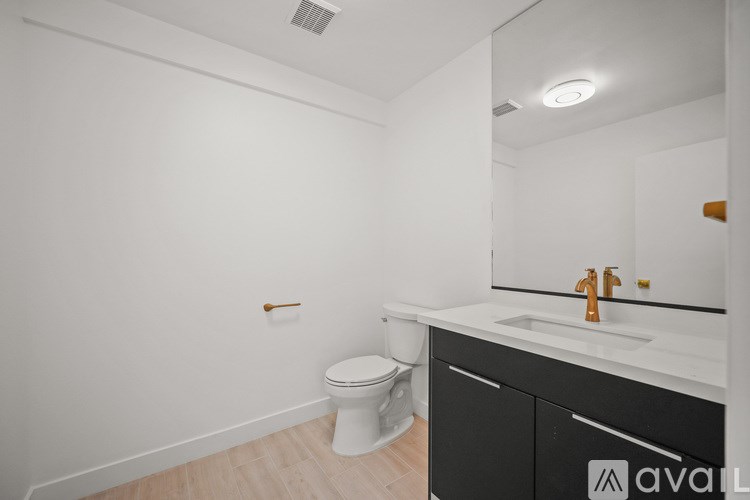 A bathroom with a toilet, sink, and mirror.